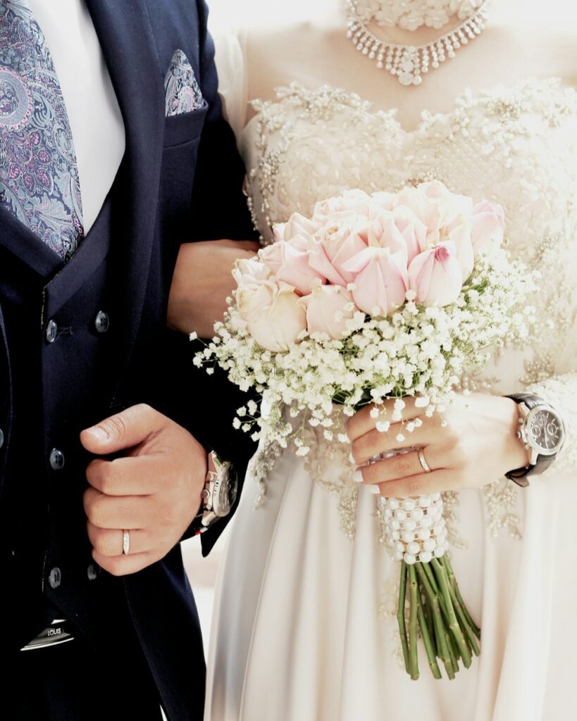 Mariée tenant un bouquet de roses et de gypsophile