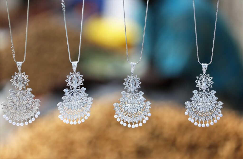 Quatre pendentifs en argent sur chaîne, à nettoyer régulièrement