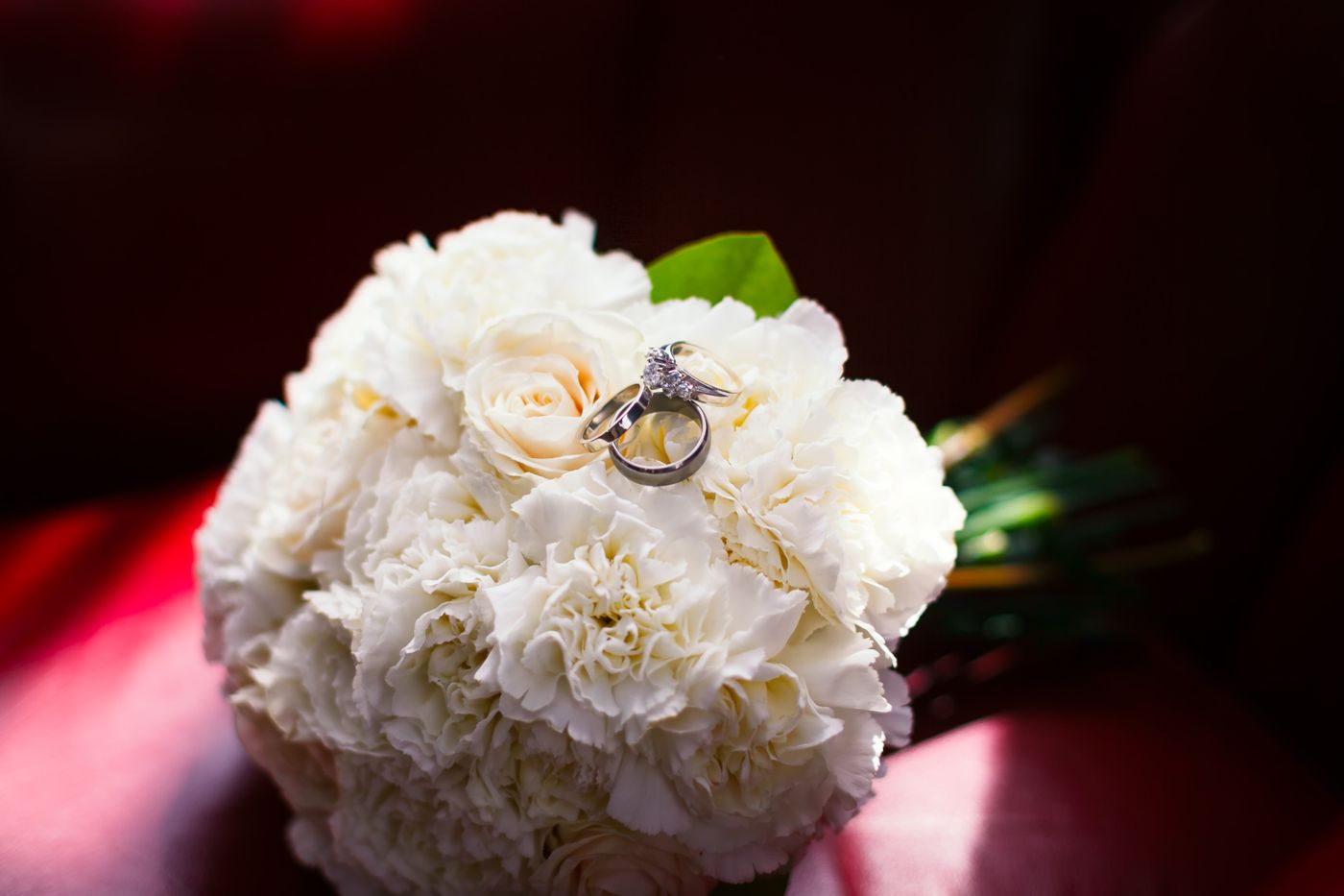 Alliances posées sur un bouquet de mariée blanc