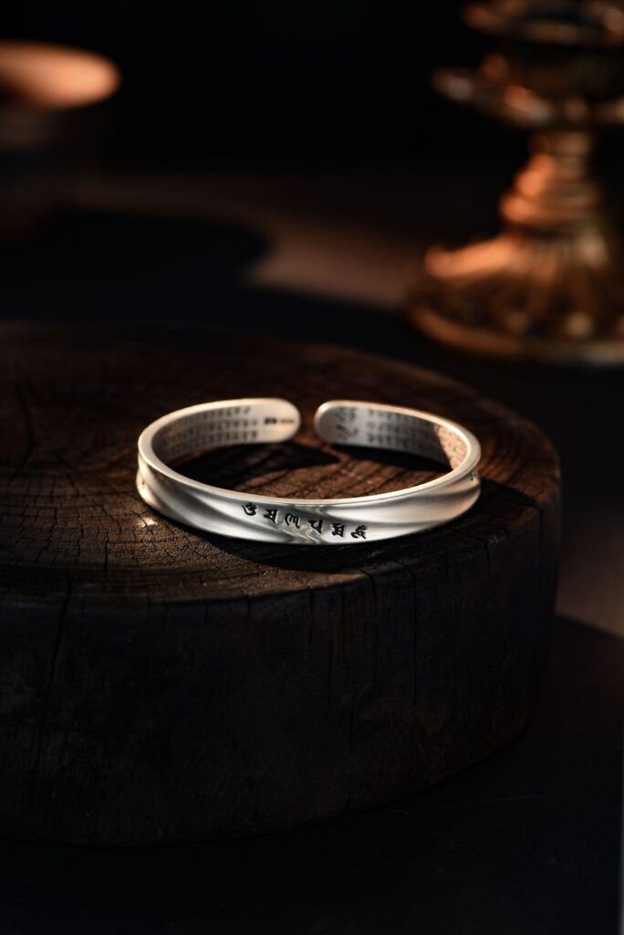 Bracelet jonc en argent posé sur un support en bois
