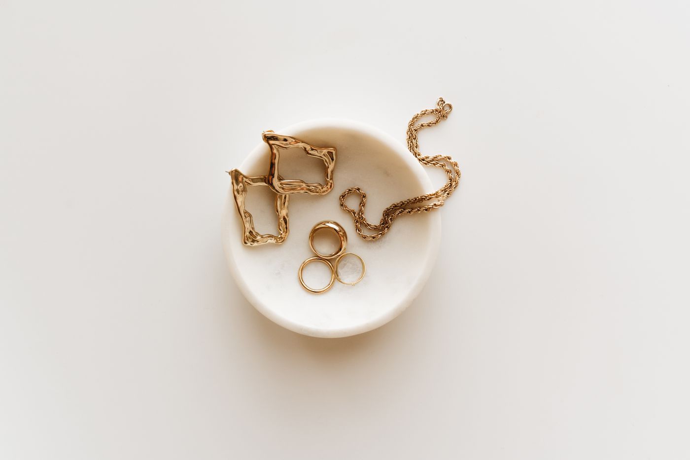 Bijoux dorés dans une coupelle en marbre sur une table de réception
